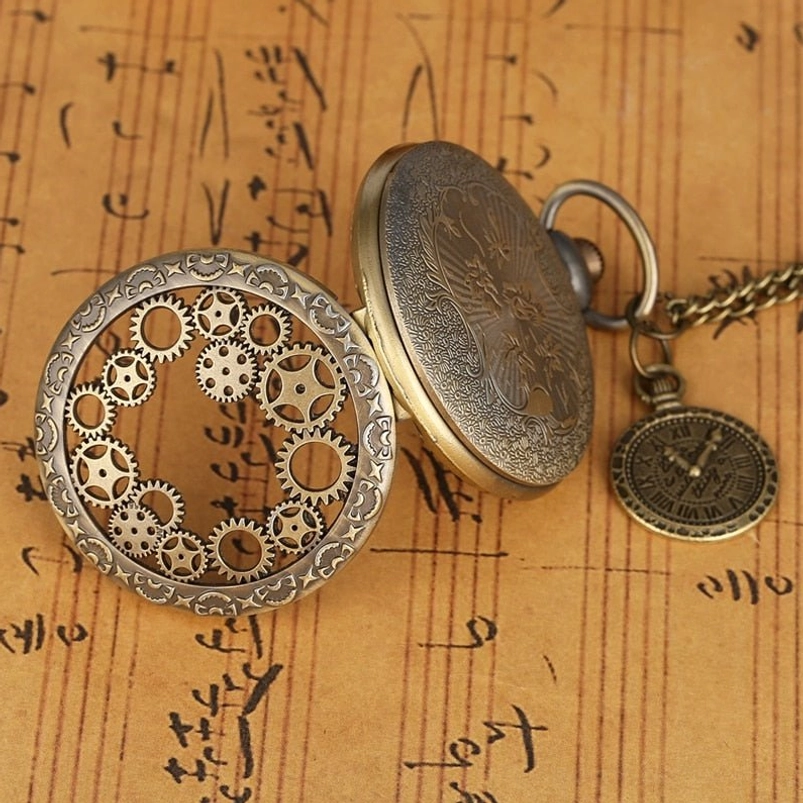Flip steampunk pocket watch flat lay side perspective showing bronze engraved rear cover, hollow gear decorative front cover, and attached miniature pocket watch charm