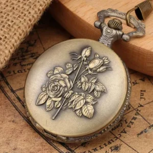 Antique bronze steampunk pocket watch with rose bouquet embossing, oblique side angle view on burlap, wooden coaster and vintage old map background, crown knob detail