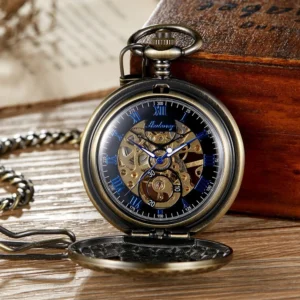 Steampunk mechanical pocket watch with black dial, blue roman numerals, exposed brass gear movement, bronze flip case shown in direct front view on vintage table