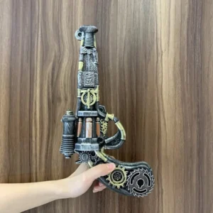 vintage steampunk toy gun with worn metal finish and exposed gear ornaments held by light-skinned female hands on wooden surface