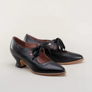 Pair of black steampunk pumps with intricate cutout details and brown leather lining, full product display view