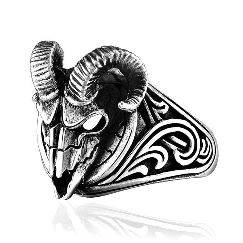 Aged blackened silver ram skull steampunk ring close-up side view highlighting bold scroll patterns and sharp details on reflective background