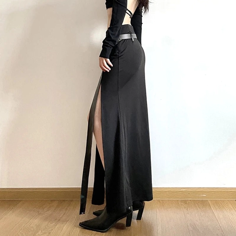 Black maxi steampunk rave skirt side rear view showing asymmetric construction with pointed heel boots