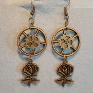 Steampunk rose gear drop earrings in bronze with hollow gear wheels and 3D rose charms, flat lay front view