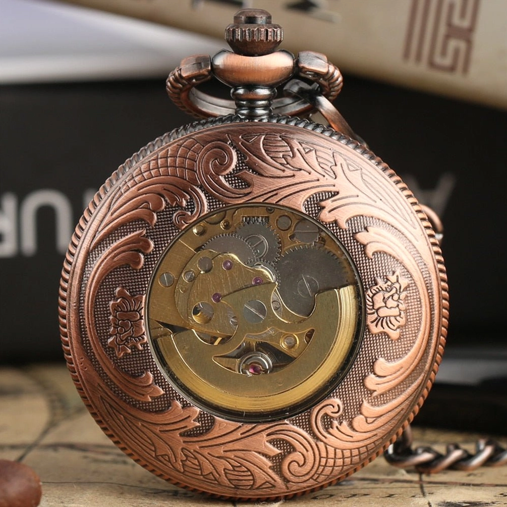 Back view of steampunk rose pocket watch showing floral engraved red copper case and transparent window revealing internal mechanical movement and gears