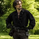 Men's black steampunk ruffle shirt with lace-up front, puffed sleeves, and ruffled jabot collar – outdoor model view