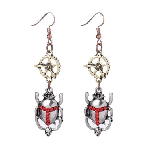 Antique silver steampunk scarab beetle drop earrings with red rhinestone accent, flat lay view