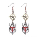Steampunk silver scarab beetle drop earrings with red rhinestone cross detail, flat lay product photography