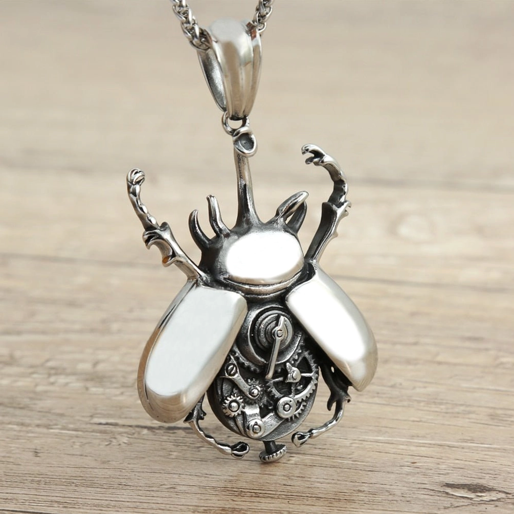 Front view of steampunk scarab beetle pendant necklace with exposed clockwork and smooth wing covers, antiqued silver on light wooden surface