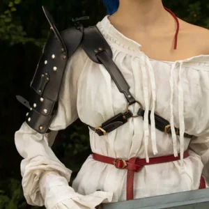 Female model with vibrant blue hair wearing steampunk black leather shoulder armor with silver rivets, paired with off-shoulder white linen blouse, front-left angle outdoor forest setting