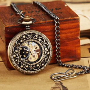 Steampunk skeleton pocket watch with carved hollow bronze frame, visible gold mechanical gears and skeleton movement, displayed with metal chain clasp on wooden box and kraft paper