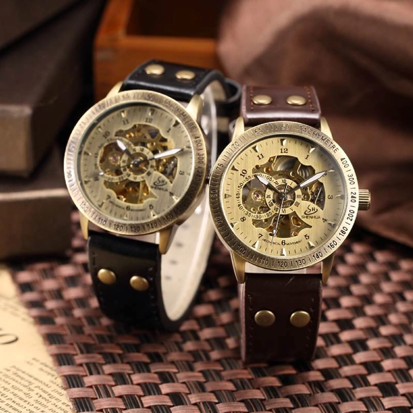 Two skeleton steampunk watches comparison - black and brown leather strap variants flat lay showing identical hollowed movement design and tachymetre bezel