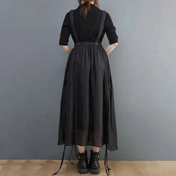 Black steampunk overall skirt back view showing full adjustable suspender system and drawstring hem tassels