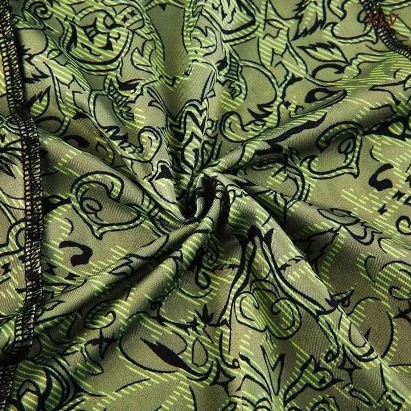 Close-up detail of olive green damask print fabric with black floral pattern and reinforced seam stitching