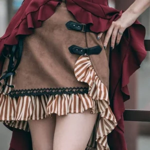 Detailed view of steampunk skirt construction showing faux-suede texture, black leather buckles, and striped ruffled hem