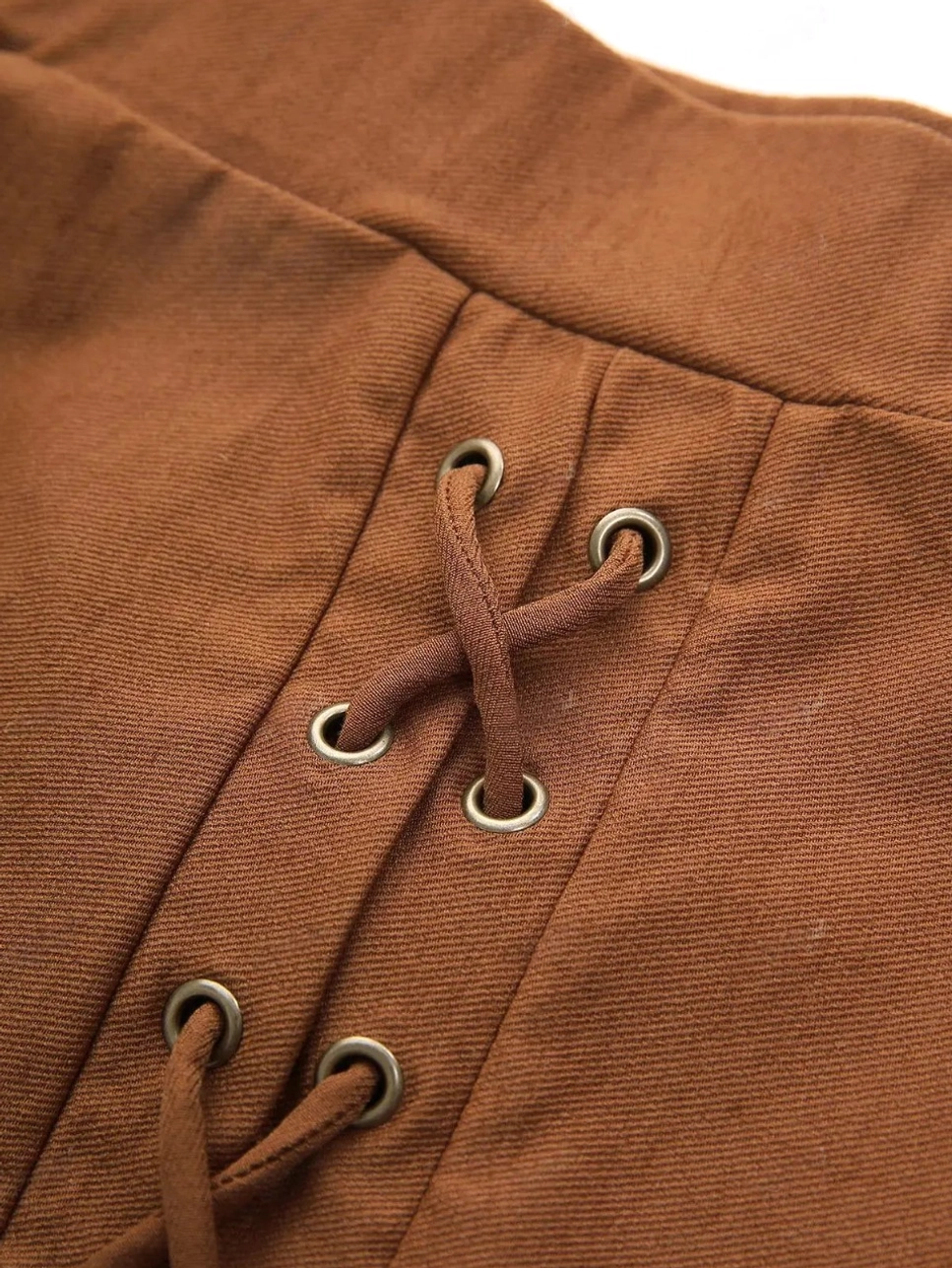 Close-up macro shot of bronze metal grommets and lace-up system on steampunk skirt, showing twill woven fabric texture and industrial eyelet details