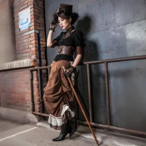 Victorian steampunk skirt with layered bustle design, brown suede with striped accents, worn with coordinating top hat and goggles by female model against industrial brick wall backdrop