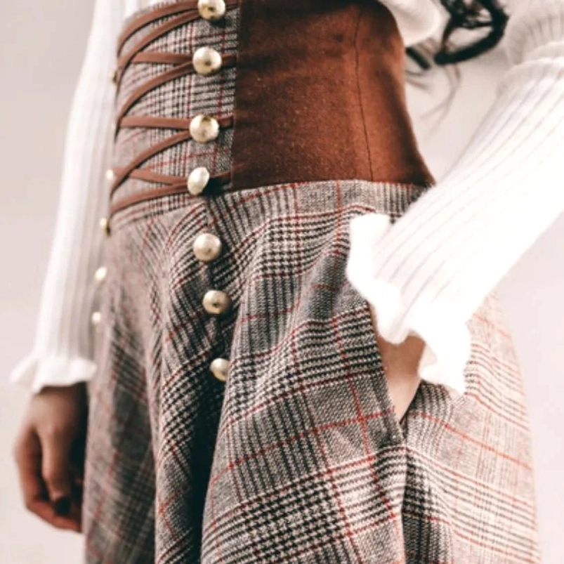 Functional side pocket detail on brown plaid steampunk skirt with crisscross leather corset accents