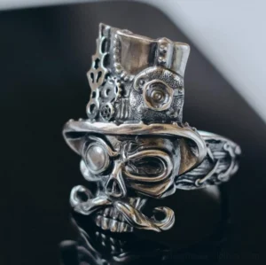 Steampunk skull gentleman ring front view with ornate gear top hat and monocle on dark reflective surface