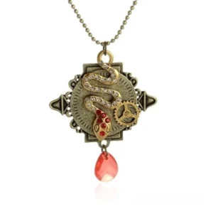 Flat lay detail view of steampunk snake pendant necklace featuring antique bronze metal, red gemstone accents, rhinestone detailing, teardrop pendant, gear ornament, and ball chain