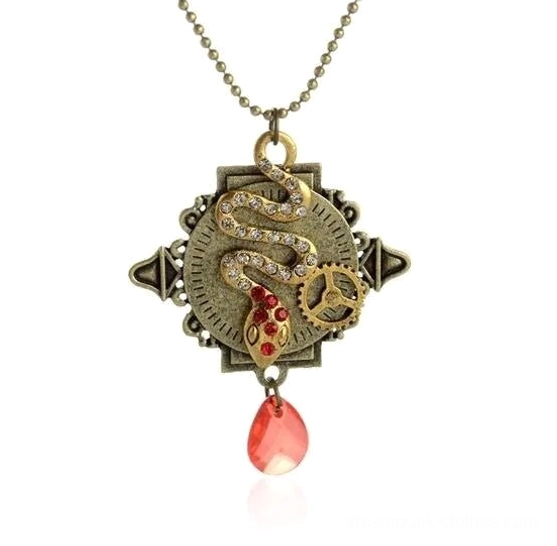 Flat lay detail view of steampunk snake pendant necklace featuring antique bronze metal, red gemstone accents, rhinestone detailing, teardrop pendant, gear ornament, and ball chain
