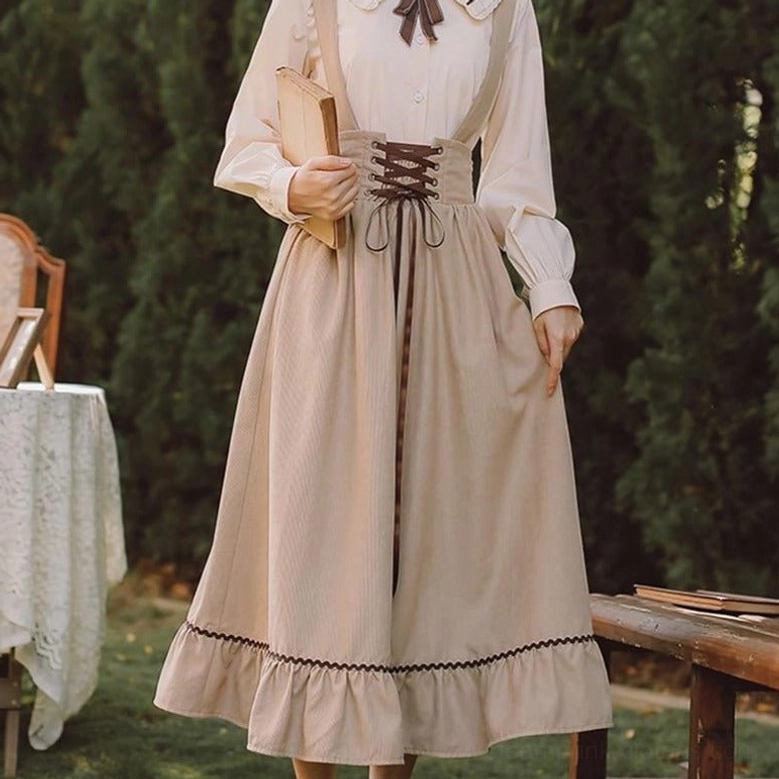 Beige steampunk suspender skirt front three-quarter view with ruffled hem and high-waisted lace-up design in garden setting