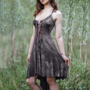 Charcoal gray tie-dye steampunk camisole dress with lace-up corset front, irregular hem, and functional pockets on model in wetland setting