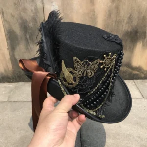 Steampunk top hat held in hand, side-rear perspective revealing full decorative trim and vintage bronze embellishments against weathered wall background