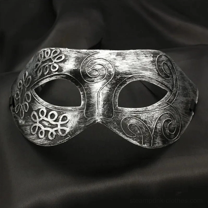 Symmetrical antique silver steampunk Venetian mask with carved scrollwork and clover patterns, front view showcasing detailed craftsmanship