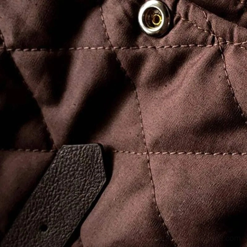 Top-down close-up of steampunk vest metal snap fastener and diamond quilting pattern