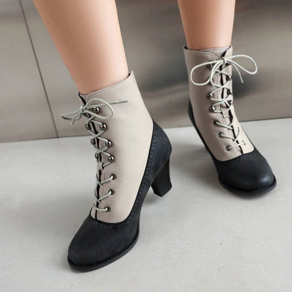 Steampunk lace-up Victorian boot front oblique - metal hardware eyelets, block high heel, two-tone industrial design