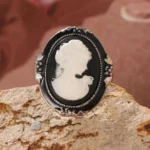 Steampunk Victorian cameo ring front view flat lay - black enamel with white relief portrait on ornate silver frame