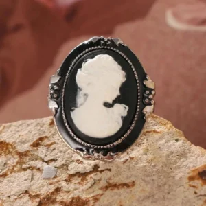 Steampunk Victorian cameo ring front view flat lay - black enamel with white relief portrait on ornate silver frame
