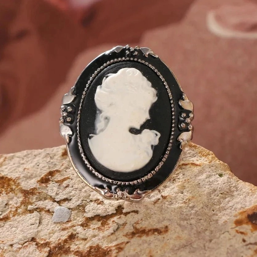 Steampunk Victorian cameo ring front view flat lay - black enamel with white relief portrait on ornate silver frame