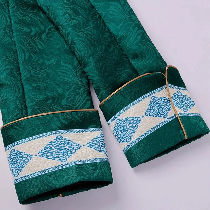 Green Victorian steampunk jacket cuff detail with blue retro embroidery and gold edge trim