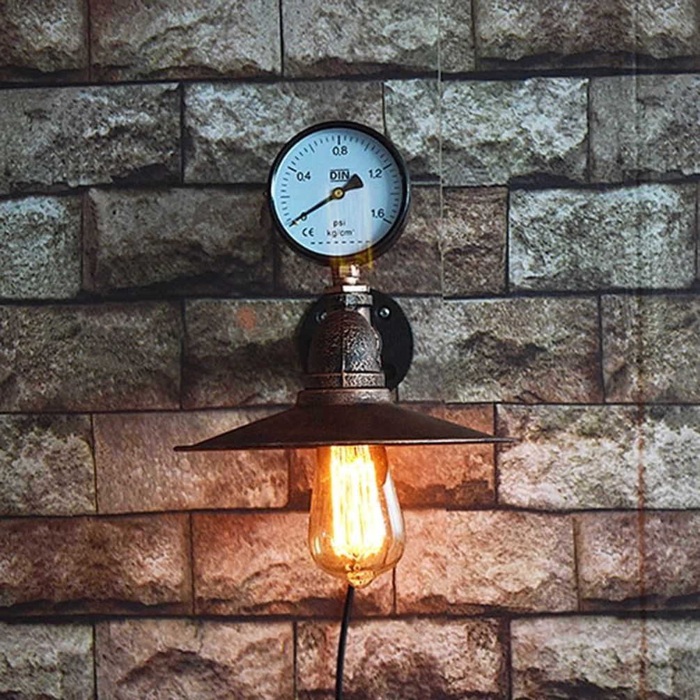 Industrial water pipe wall lamp lit up against brick background, featuring distressed copper piping joints and glowing Edison bulb, frontal view of steampunk lamp