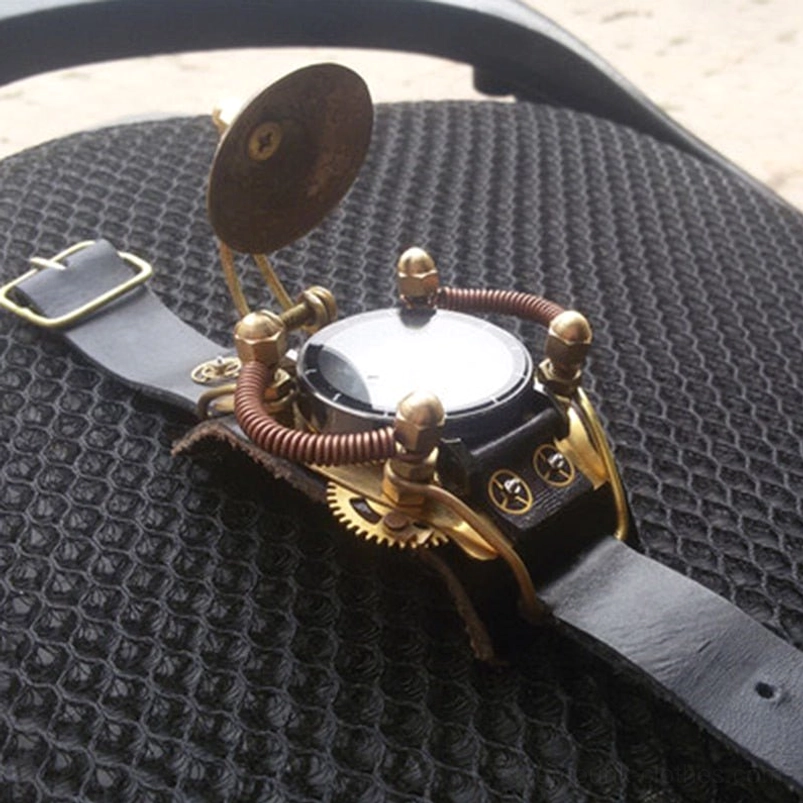 Steampunk mechanical wristwatch featuring brass disc accessory and copper coil work with visible gear elements, oblique top view on car fabric background