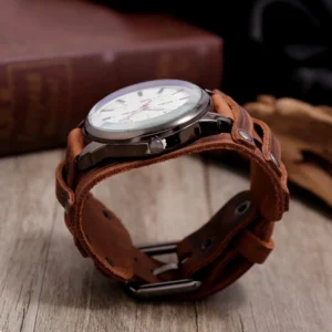 Brown leather steampunk watch side view, metal buckle closure and round white dial, vintage dark fabric background