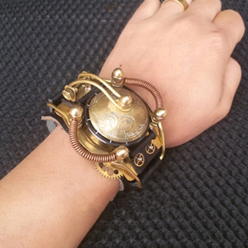 Steampunk enclosed wristwatch with closed brass cover, copper coil wrapping, and gear decorations, worn on left hand with ornamental ring against fabric background