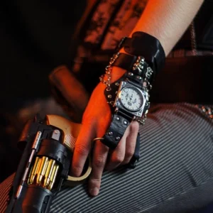 Steampunk leather watch with skull charms and chain details, worn on wrist with vintage revolver prop, showcasing industrial square dial and black-silver color scheme