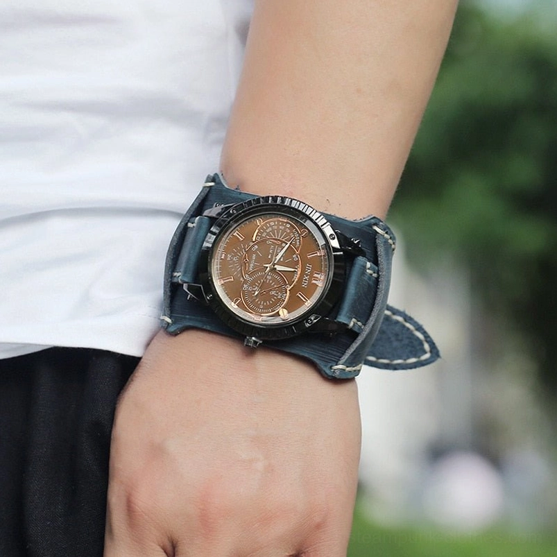 Steampunk leather wristwatch worn on wrist outdoor with dark blue strap, gunmetal case, and copper-toned decorative dial