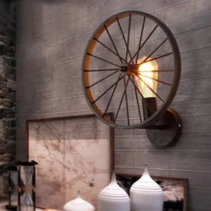 Industrial steampunk wagon wheel wall lamp three-quarter view on grey accent wall with vintage tabletop ornaments, authentic vintage home decor styling