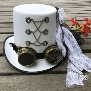 White steampunk top hat with brass goggles and gear chain embellishments displayed on wooden deck with red flowers background, front flat lay view