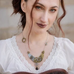 Steampunk wing gear necklace with dual metal tones worn on model in vintage lace-trim blouse, featuring brass and silver mixed metals with black teardrop pendant and intricate gear details
