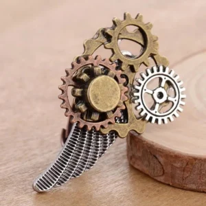 Adjustable steampunk wing ring featuring intricate gear cluster and striped textured wing detail, right 3/4 perspective on wooden surface - industrial aesthetic ring