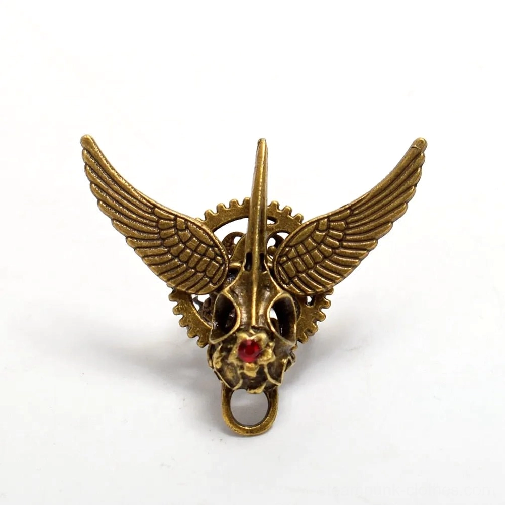 Direct front view of steampunk winged skull ring showing bronze metal, red gemstone inlay, and mechanical wing design