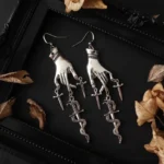 Steampunk witch hand dagger earrings antique silver vintage flat lay with dried autumn leaves