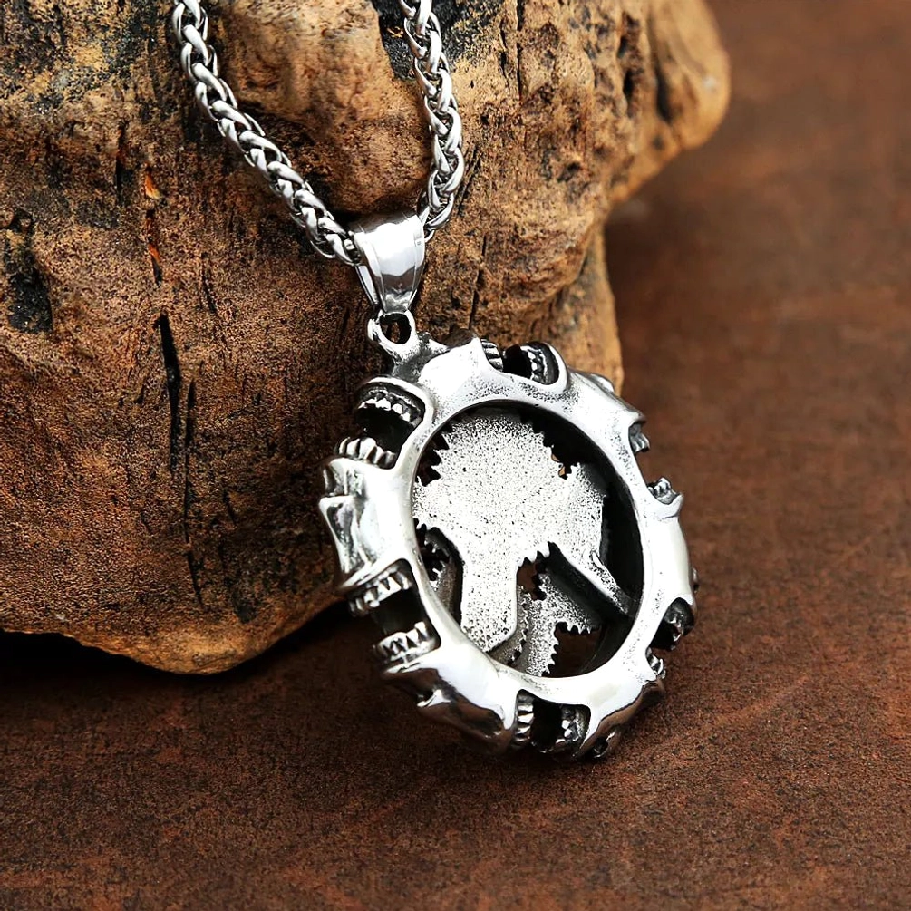 Steampunk wolf head pendant necklace with carved silver wolf inside hollow spiked circular frame, vintage-inspired industrial design on brown leather background