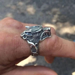 Wolf head ring worn on male hand, showing intricate vine pattern band and fierce wolf carving, steampunk men's jewelry