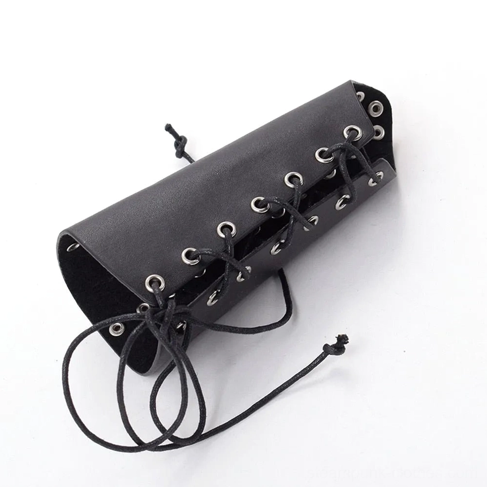 Black PU leather wrist guard with metal eyelets and adjustable drawstring lace-up fastening system, angled top-down flat lay view